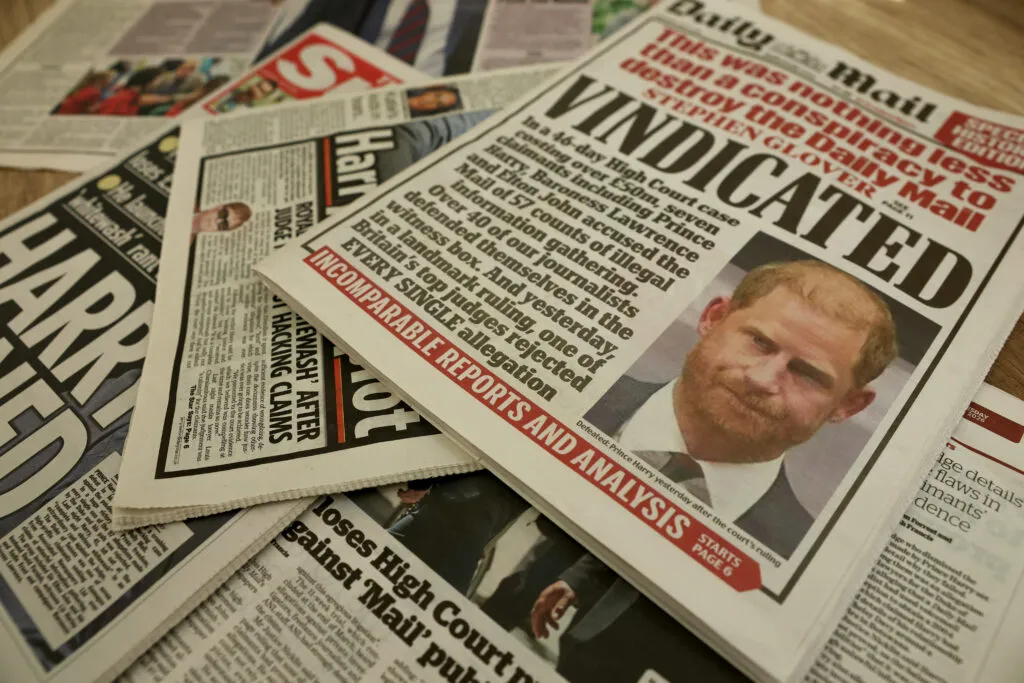 A photo illustration of British newspapers reporting on a High Court verdict, showing the media spotlight
